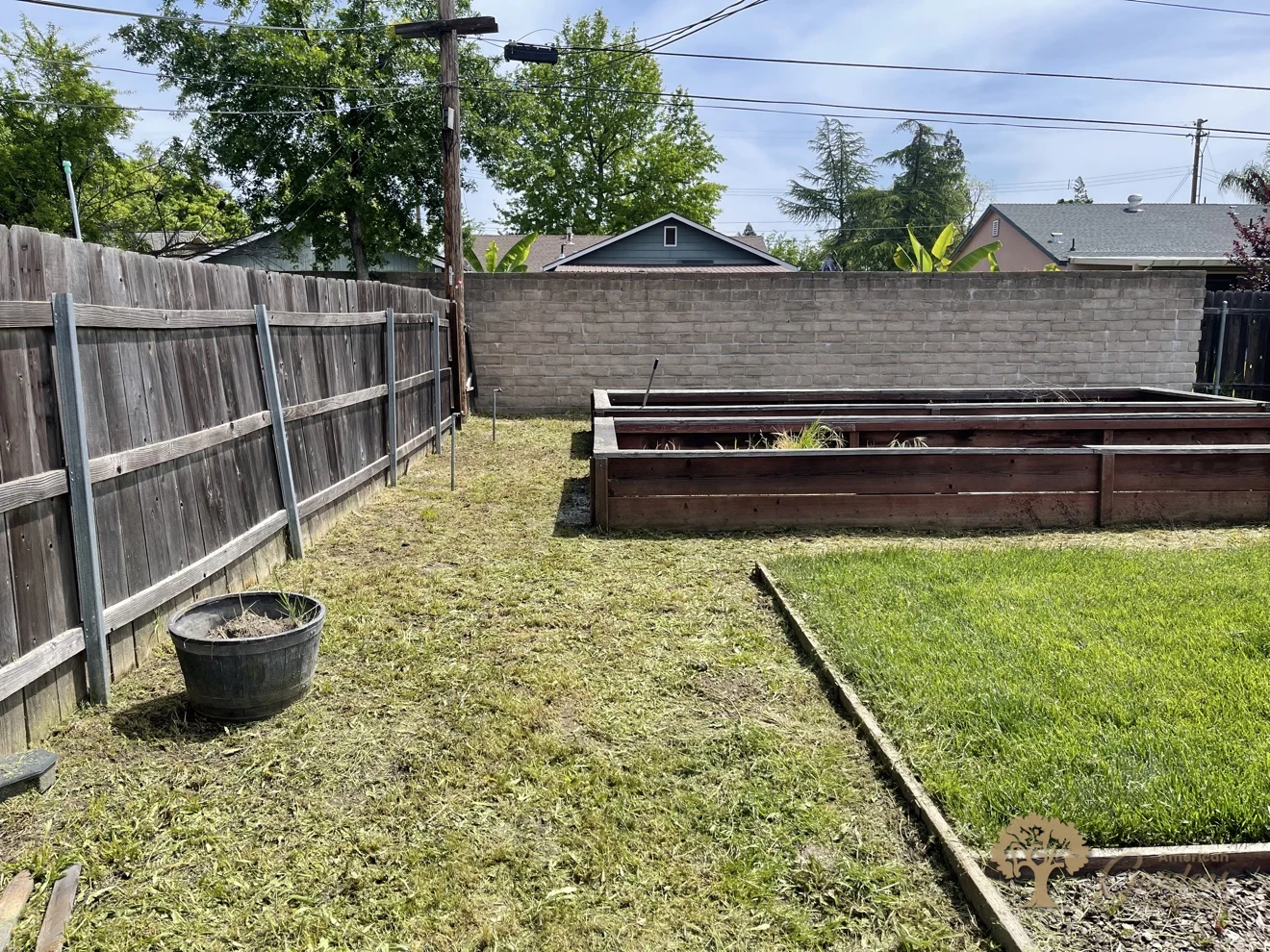 Clean backyard with raised beds and trimmed lawn after a full weeding and cleanup in Carmichael