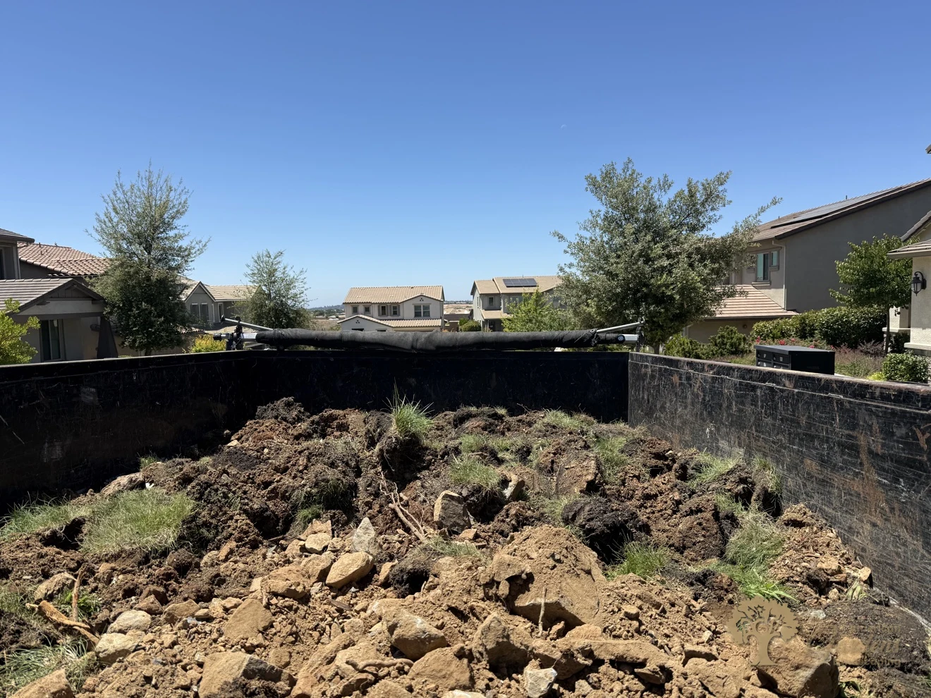 Excavated rocky slope at the start of a terraced backyard rebuild in El Dorado Hills' Serrano neighborhood, by American Gardens Landscaping.
