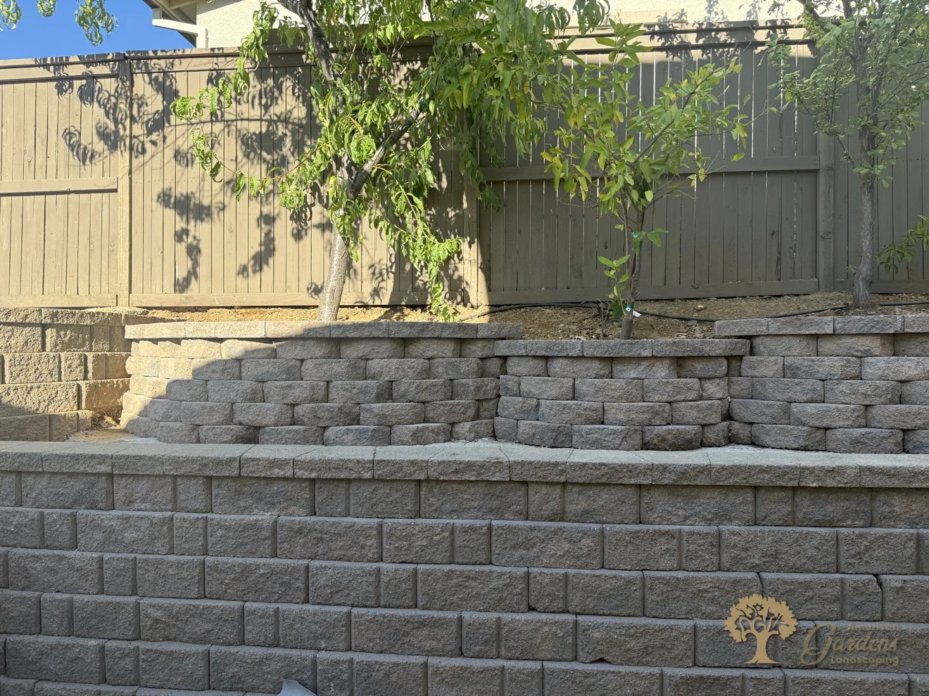 Two levels of finished block retaining walls terracing a Serrano backyard in El Dorado Hills, by American Gardens Landscaping.