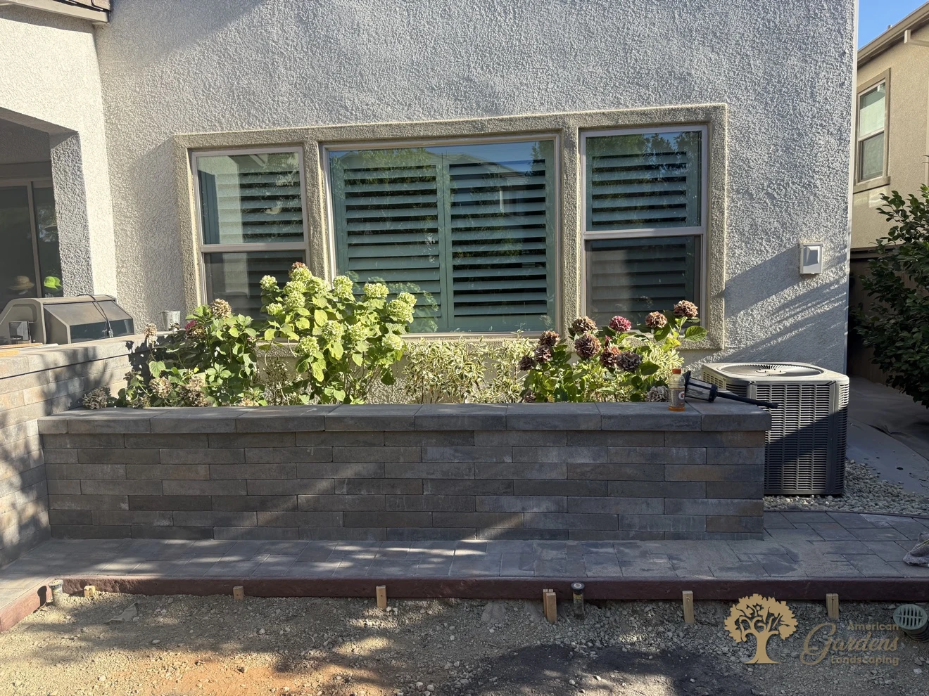 Completed paver platform in front of the new raised planter, before the lawn went in, in a Serrano backyard in El Dorado Hills, by American Gardens Landscaping.