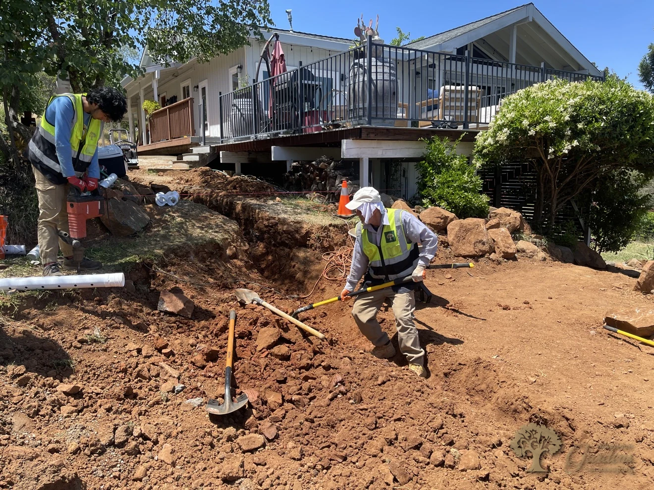 Crew excavating a rocky hillside with a jackhammer to build pressure-treated wood steps in Shingle Springs – American Gardens Landscaping