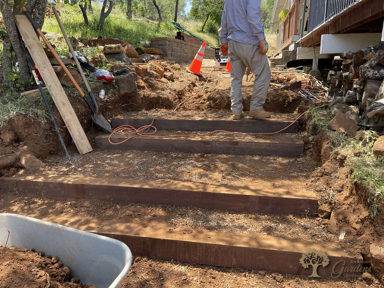 Pressure-treated timber steps being set into a hillside in Shingle Springs – American Gardens Landscaping