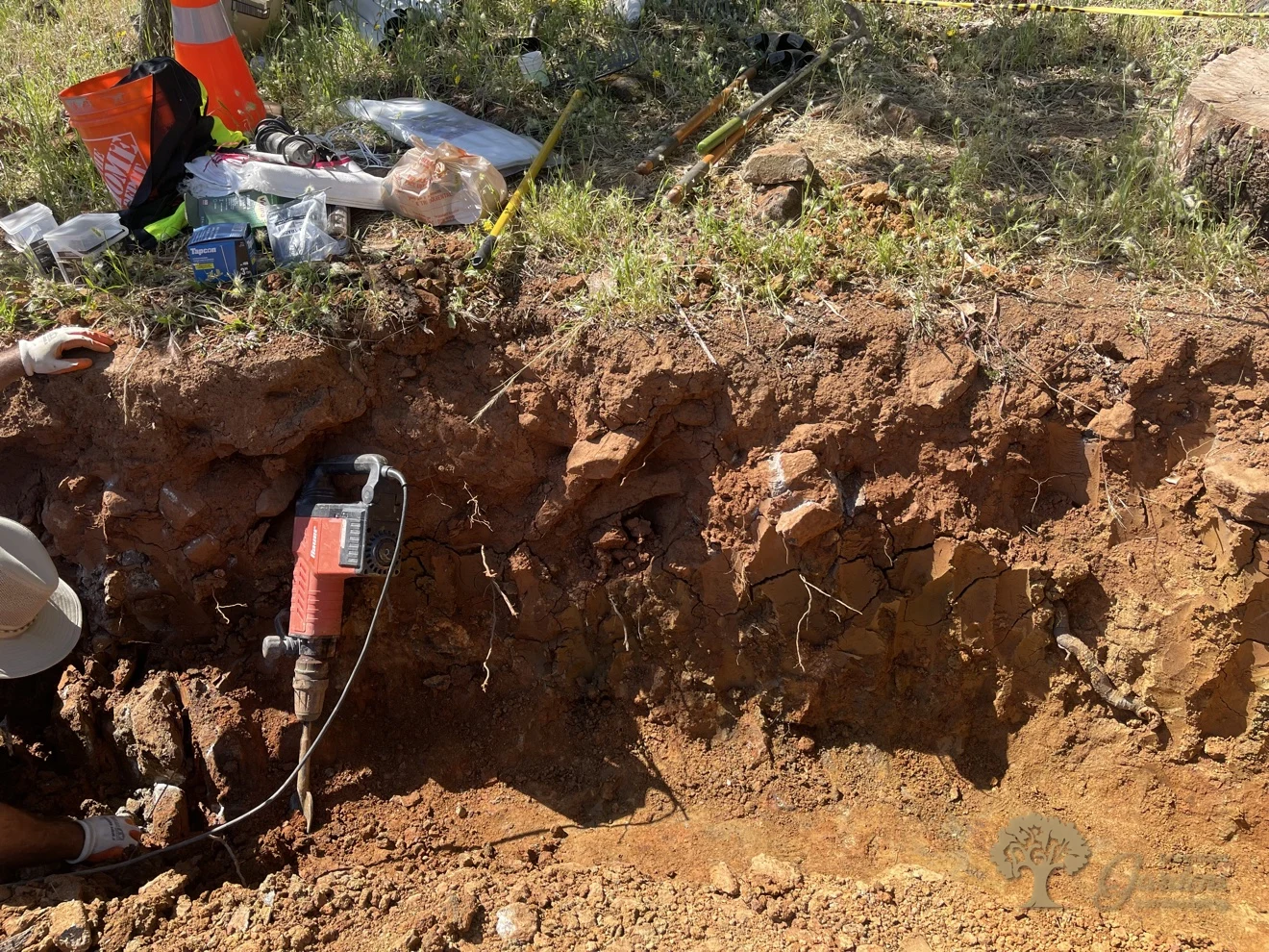 Jackhammer breaking rocky soil in a retaining wall trench, Shingle Springs