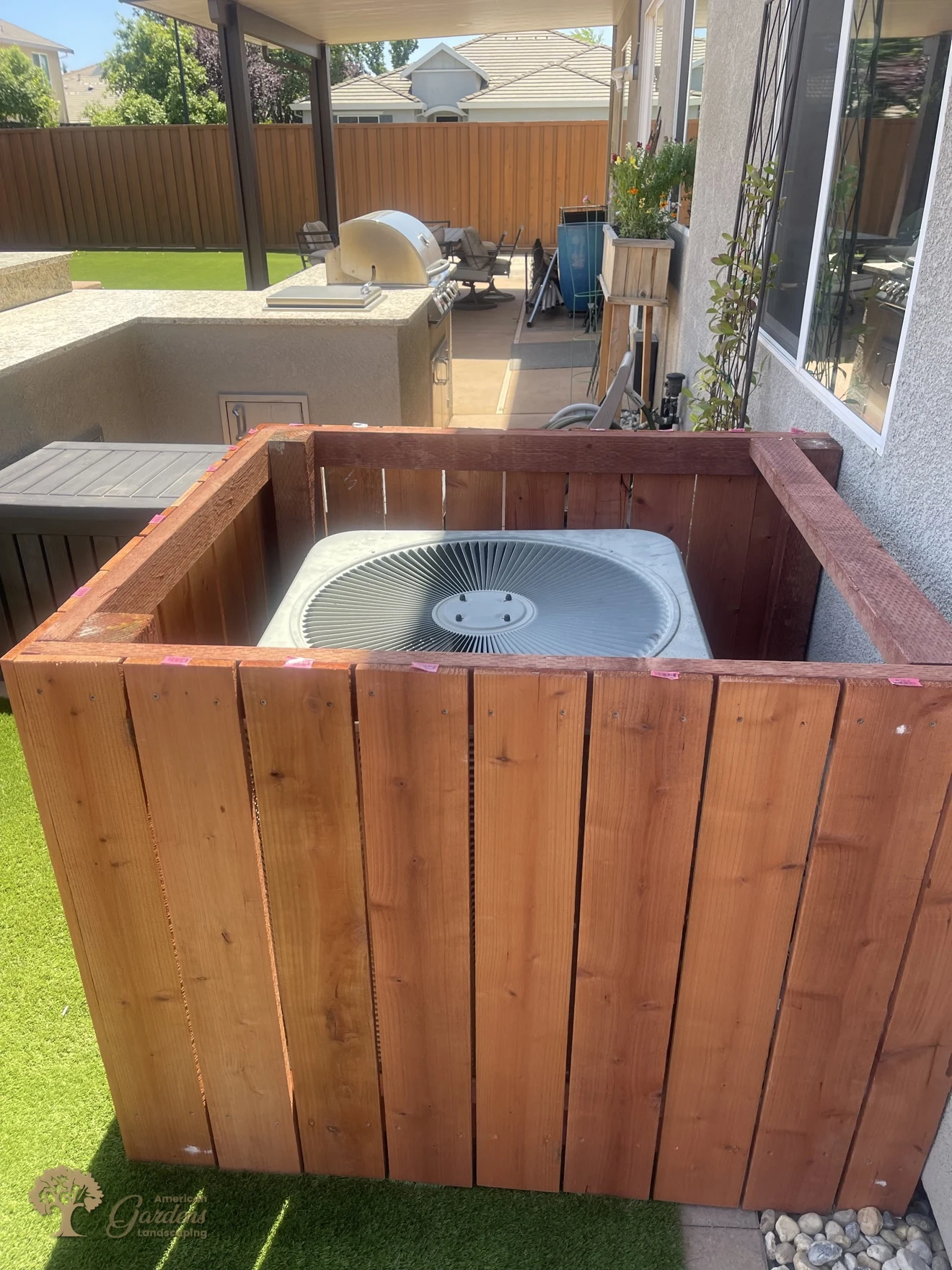 AC unit screened by the finished redwood enclosure in Rocklin – American Gardens Landscaping