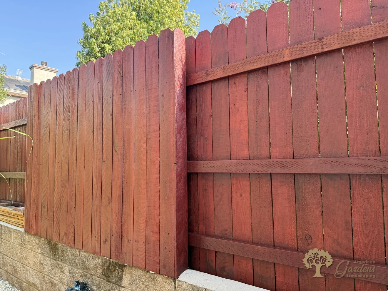 Stained redwood fence corner on a block wall in Rocklin – American Gardens Landscaping