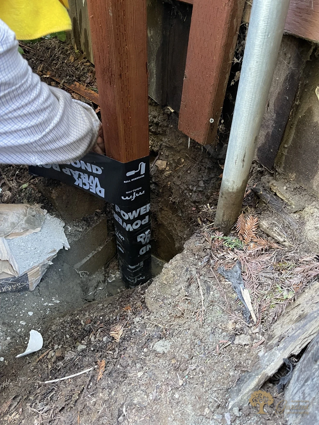 Close-up of a Simpson steel connector securing a redwood fence post during a fence installation by American Gardens Landscaping in Sacramento