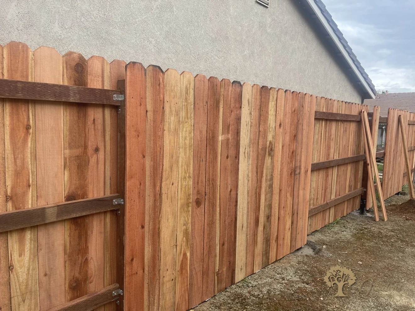 Finished redwood fence installation alongside a house by American Gardens Landscaping in Fair Oaks