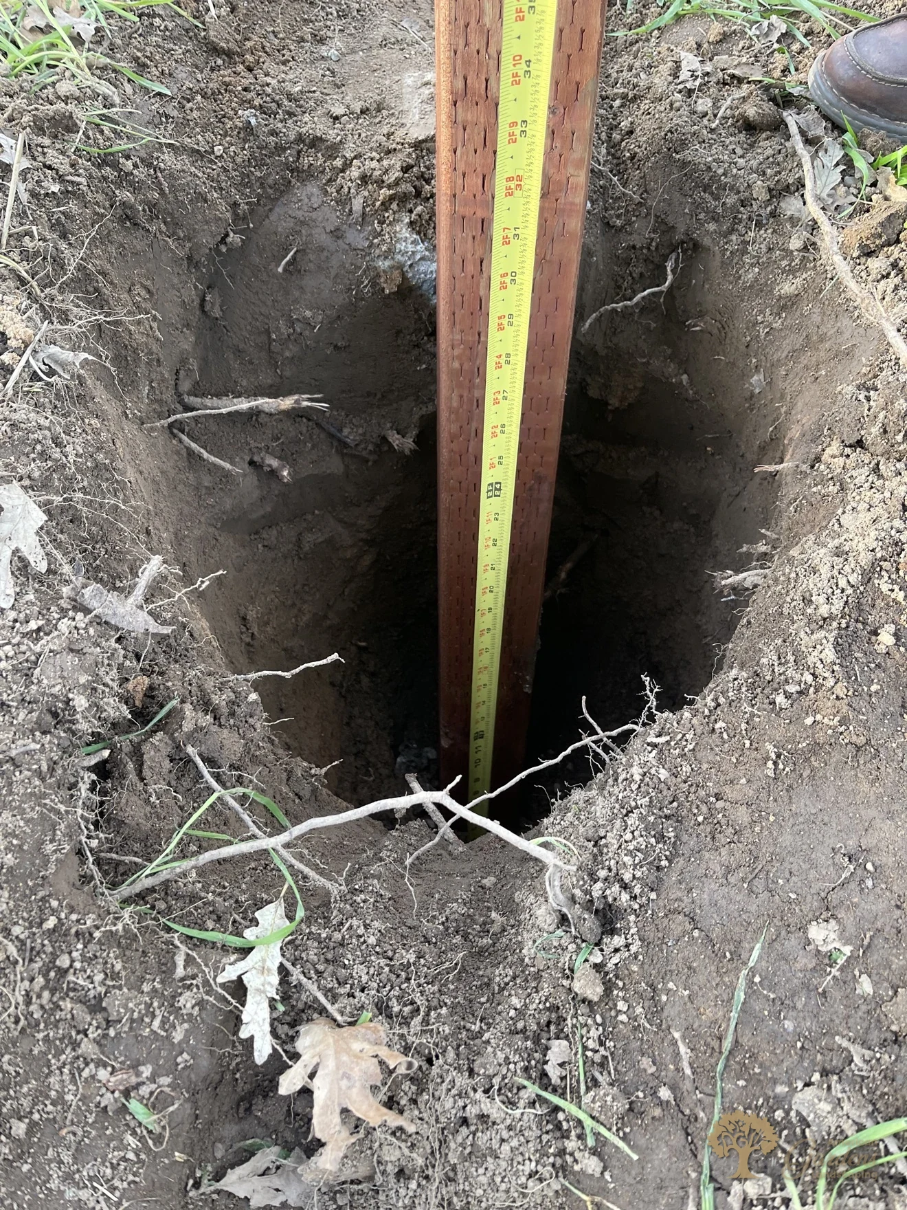 About three-foot-deep fence post hole with waterproof post wrap on the post, prepared by American Gardens Landscaping in Sacramento