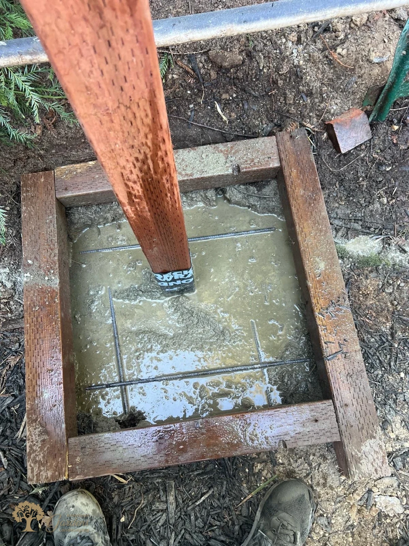 Fence post footing with rebar reinforcement prepared for concrete by American Gardens Landscaping in Fair Oaks
