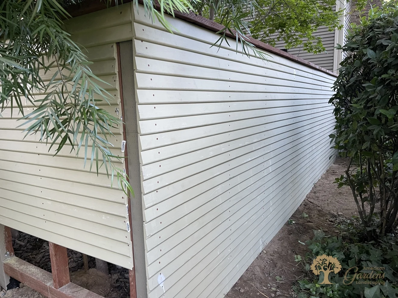 The finished long run of the painted replacement fence seen from the outside in Sacramento, clean lines and neat screw rows, built to HOA rules by American Gardens Landscaping