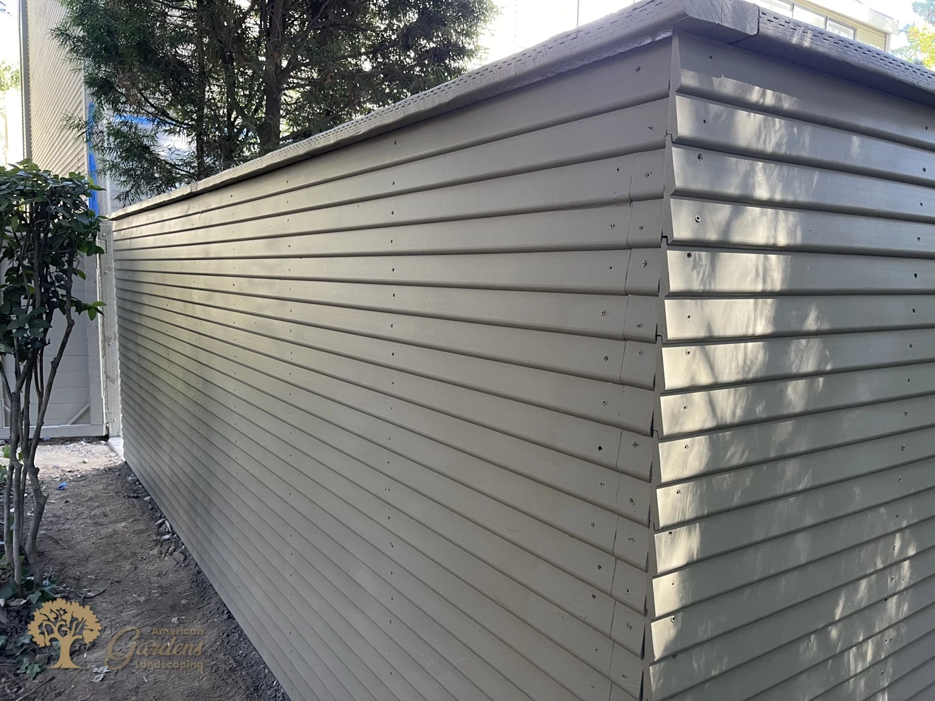 A long finished run of the painted replacement fence with a mitered corner, built to HOA rules in a Sacramento gated community by American Gardens Landscaping