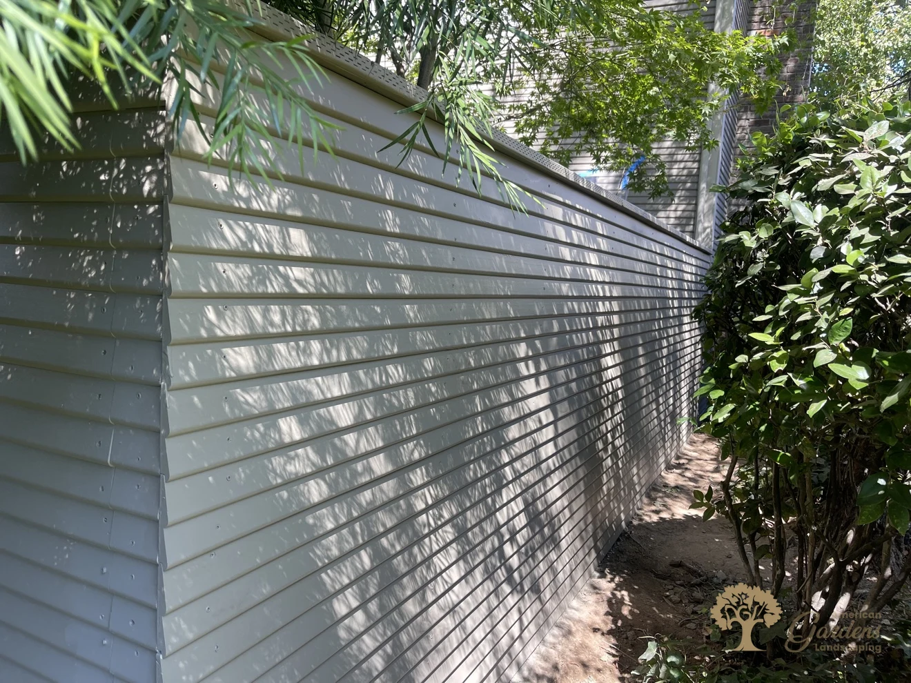 A long finished run of the painted replacement fence seen from the outside in Sacramento, with clean panel joints and neat screw rows, built to HOA rules by American Gardens Landscaping