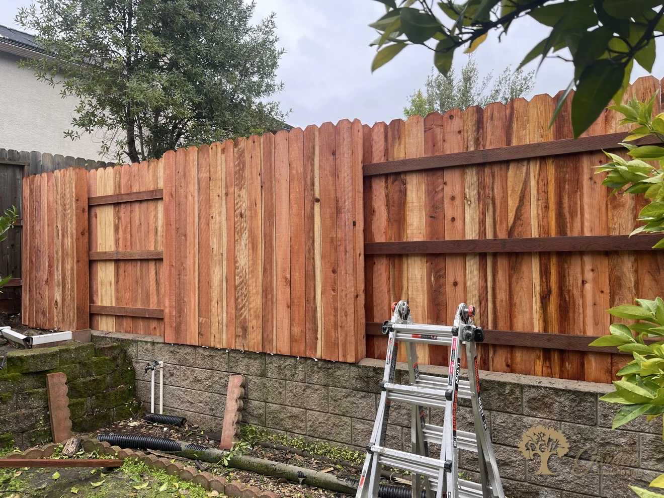 Redwood fence installed on a block retaining wall in Folsom – American Gardens Landscaping