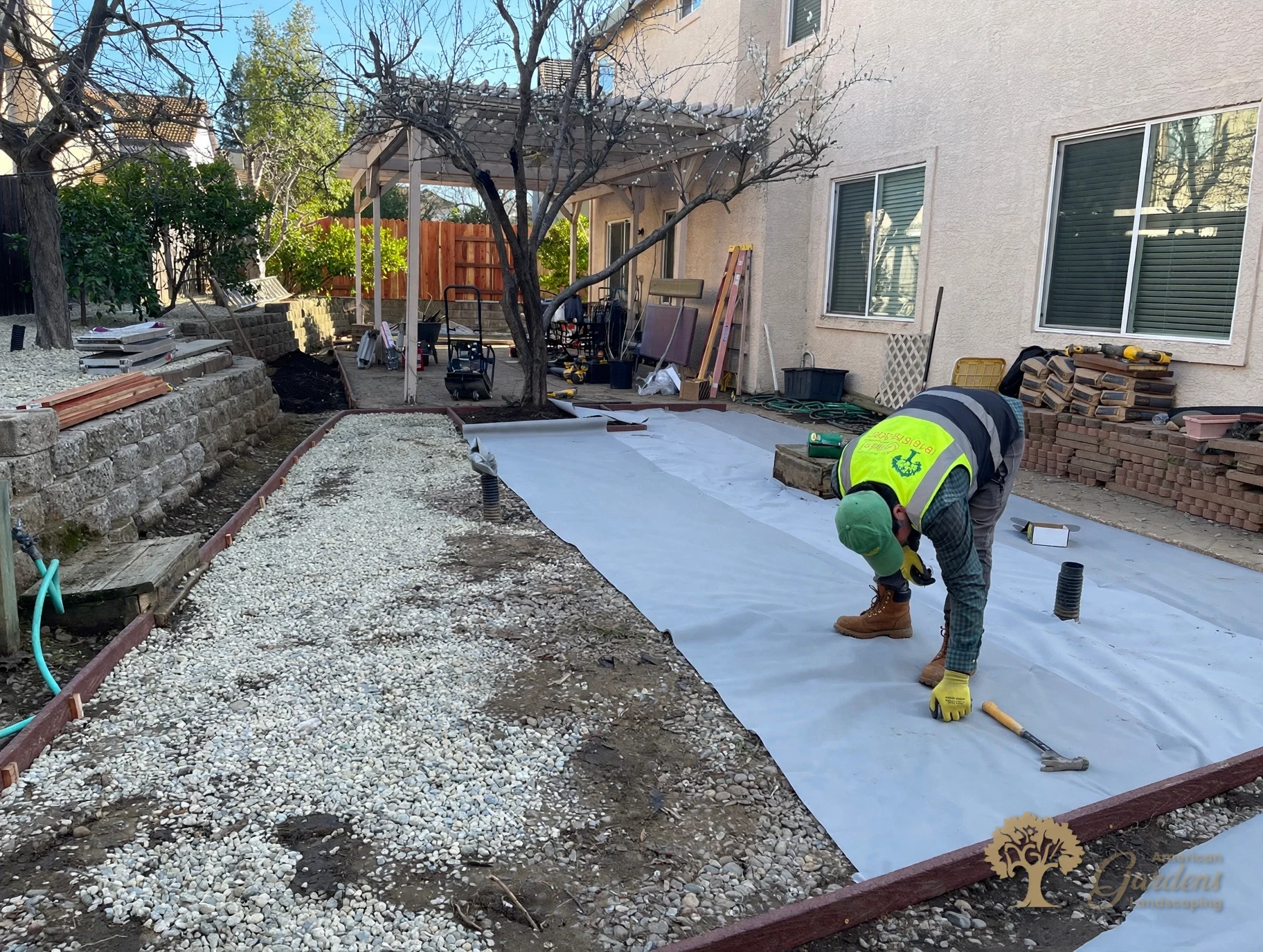 Laying and pinning weed-barrier fabric under the turf in Folsom – American Gardens Landscaping