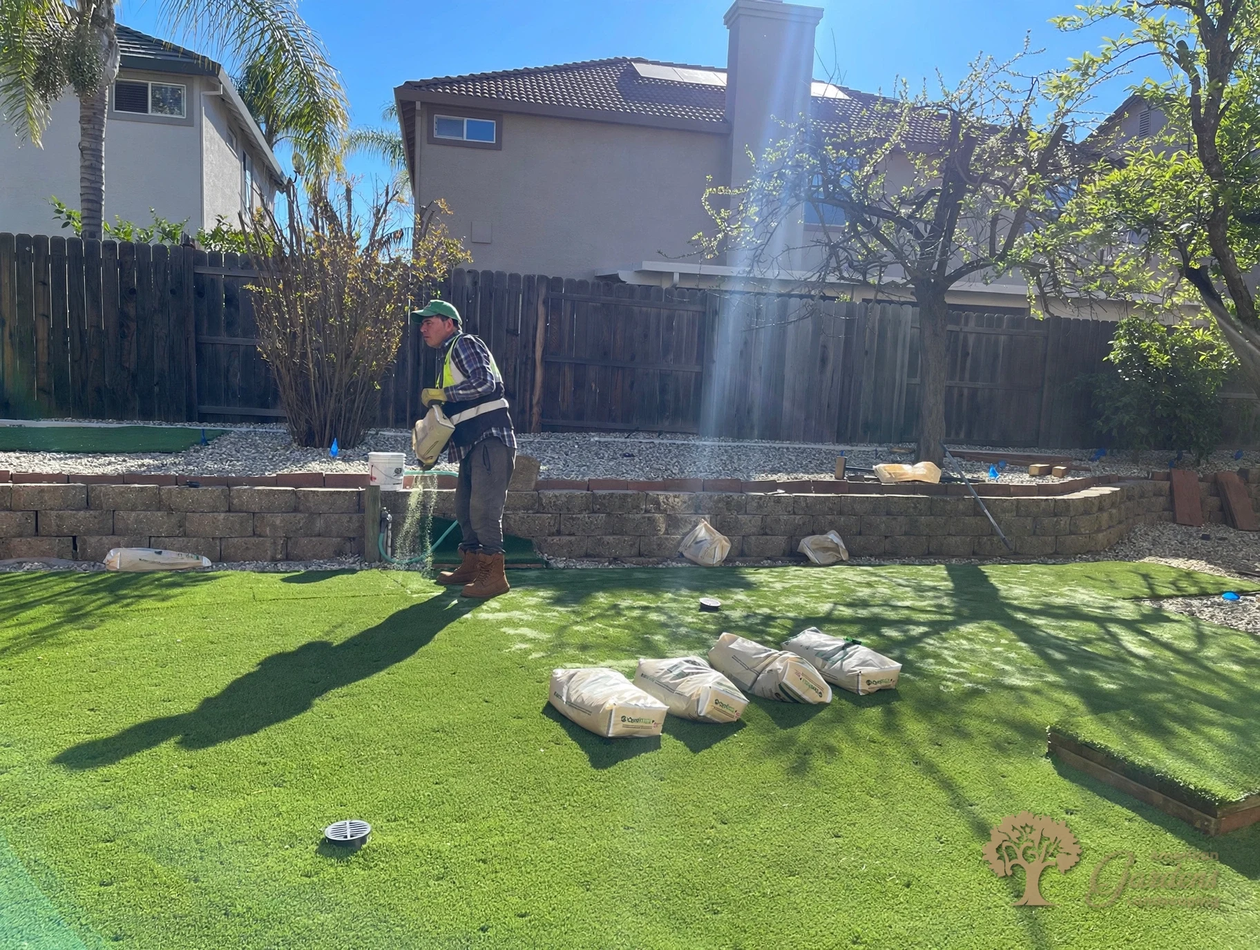 Spreading infill over the finished artificial grass in Folsom – American Gardens Landscaping
