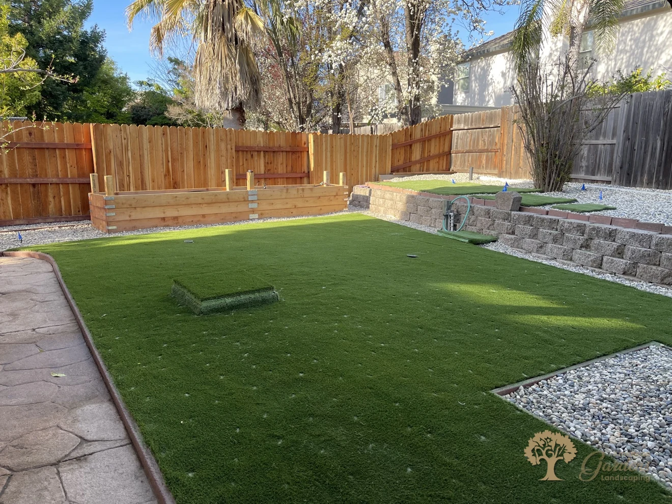 Finished artificial grass backyard with new redwood fence and raised bed in Folsom – American Gardens Landscaping