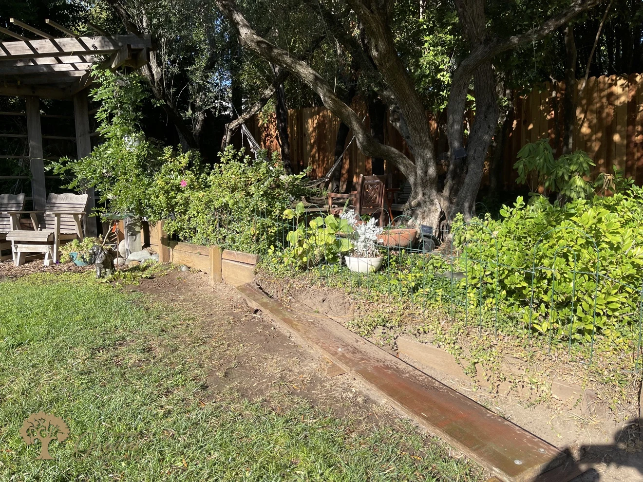 The garden bed edge in Fair Oaks after the old railroad-tie timber wall was removed, ready for the new pressure-treated retaining wall by American Gardens Landscaping