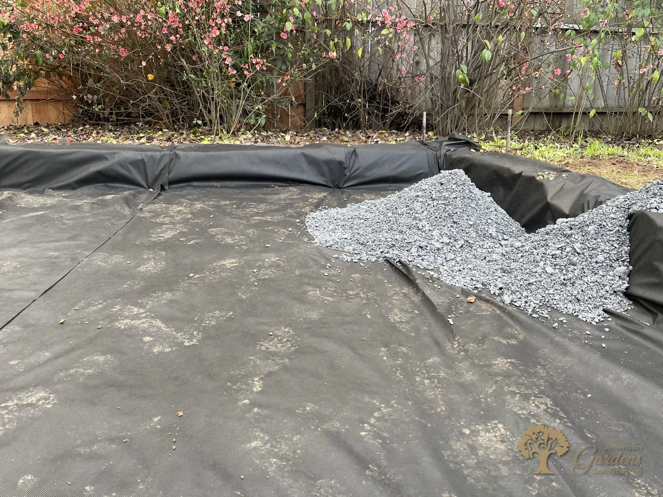 Base rock being spread over geotextile fabric for a herringbone paver patio in Sacramento – American Gardens Landscaping