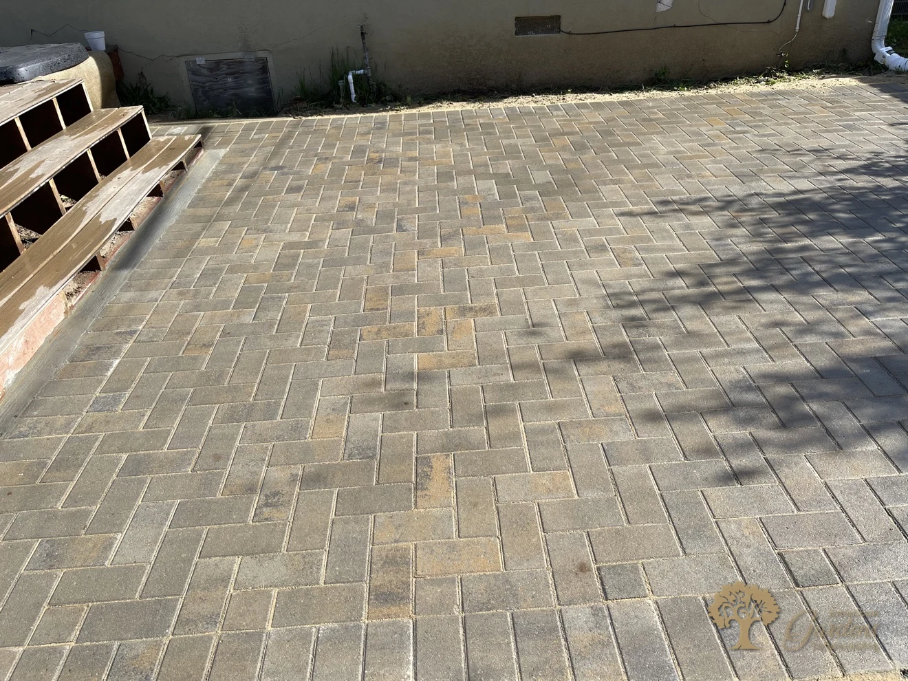 Finished herringbone paver patio beside the deck and house in Sacramento – American Gardens Landscaping