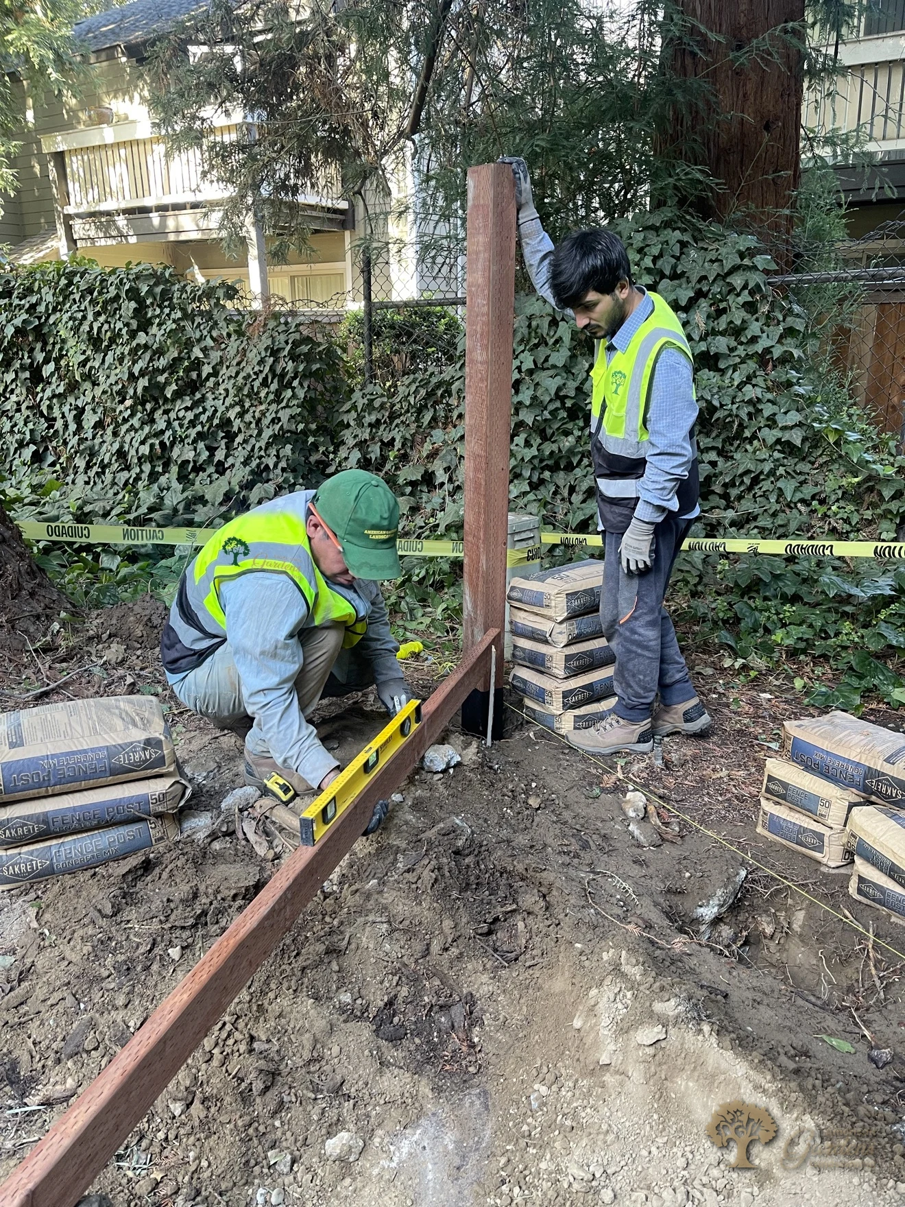 Workers in uniform setting the first fence posts - Sacramento HOA fence replacement