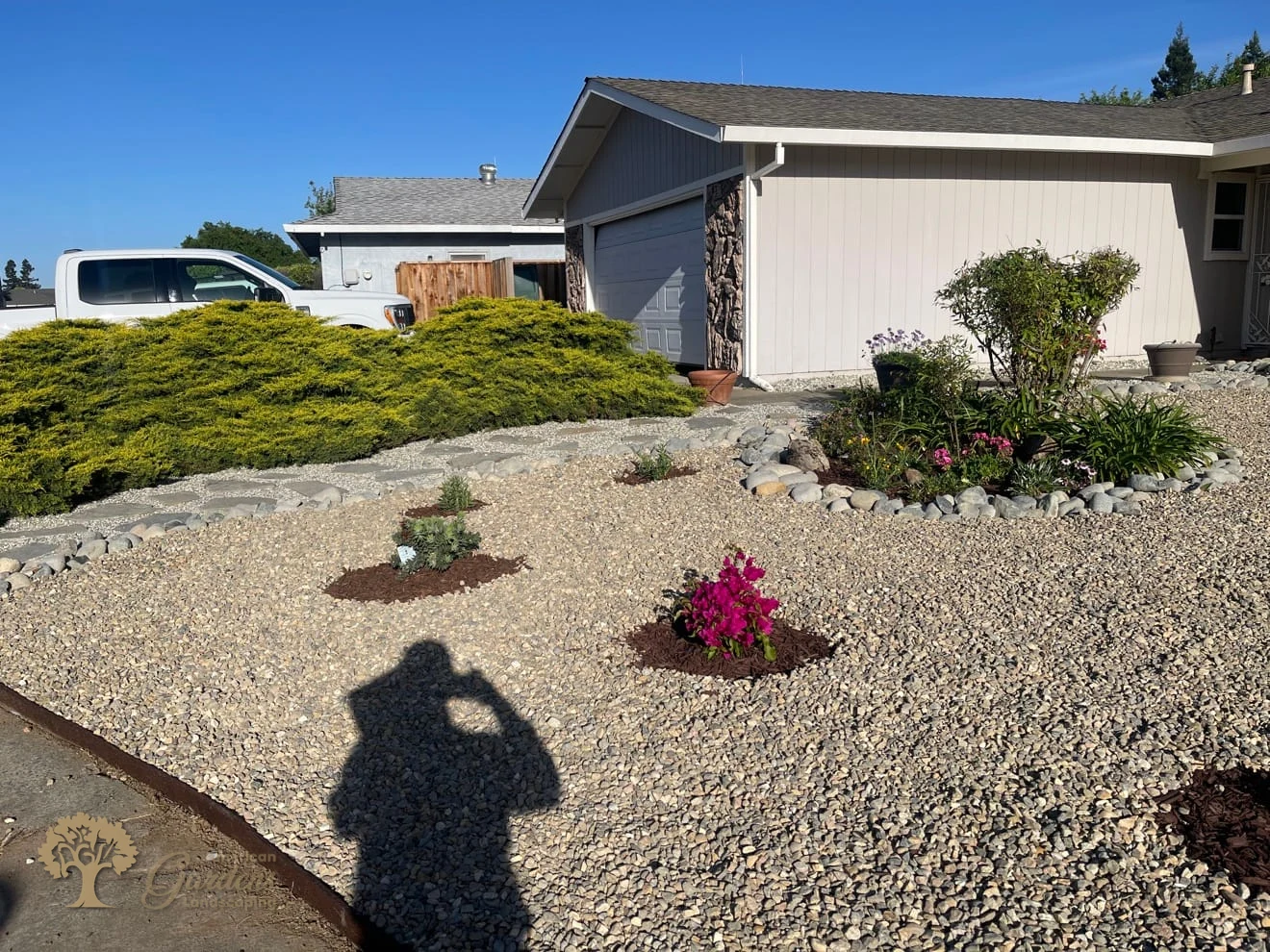 Water-wise front yard with light gravel, a flagstone stepping-stone path, river-rock borders and new drought-tolerant plants by American Gardens Landscaping in the Sacramento area