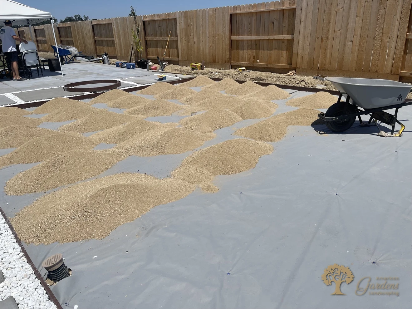 Decomposed granite piles dumped in rows on weed fabric at the start of a DG installation by American Gardens Landscaping