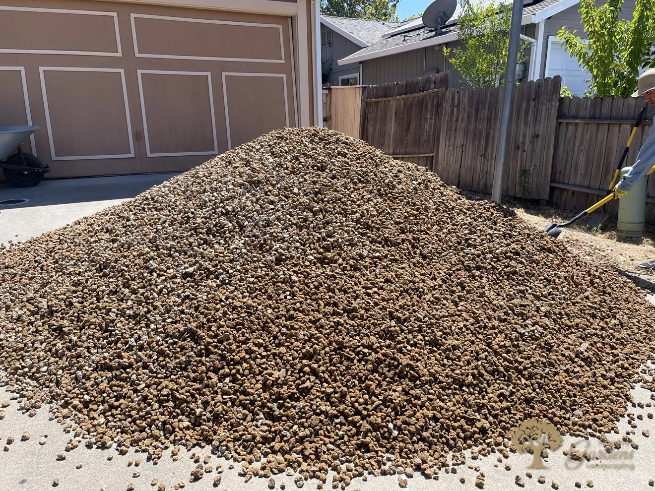 A large pile of gravel delivered on the driveway for a front-yard xeriscape conversion in Rancho Cordova by American Gardens Landscaping