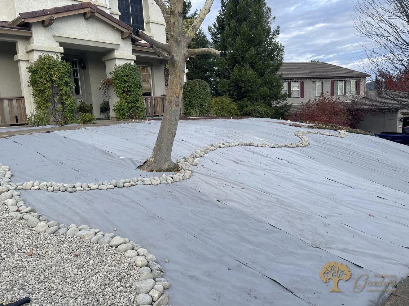 Weed fabric and a river-rock dry creek laid over the slope in El Dorado Hills – American Gardens Landscaping