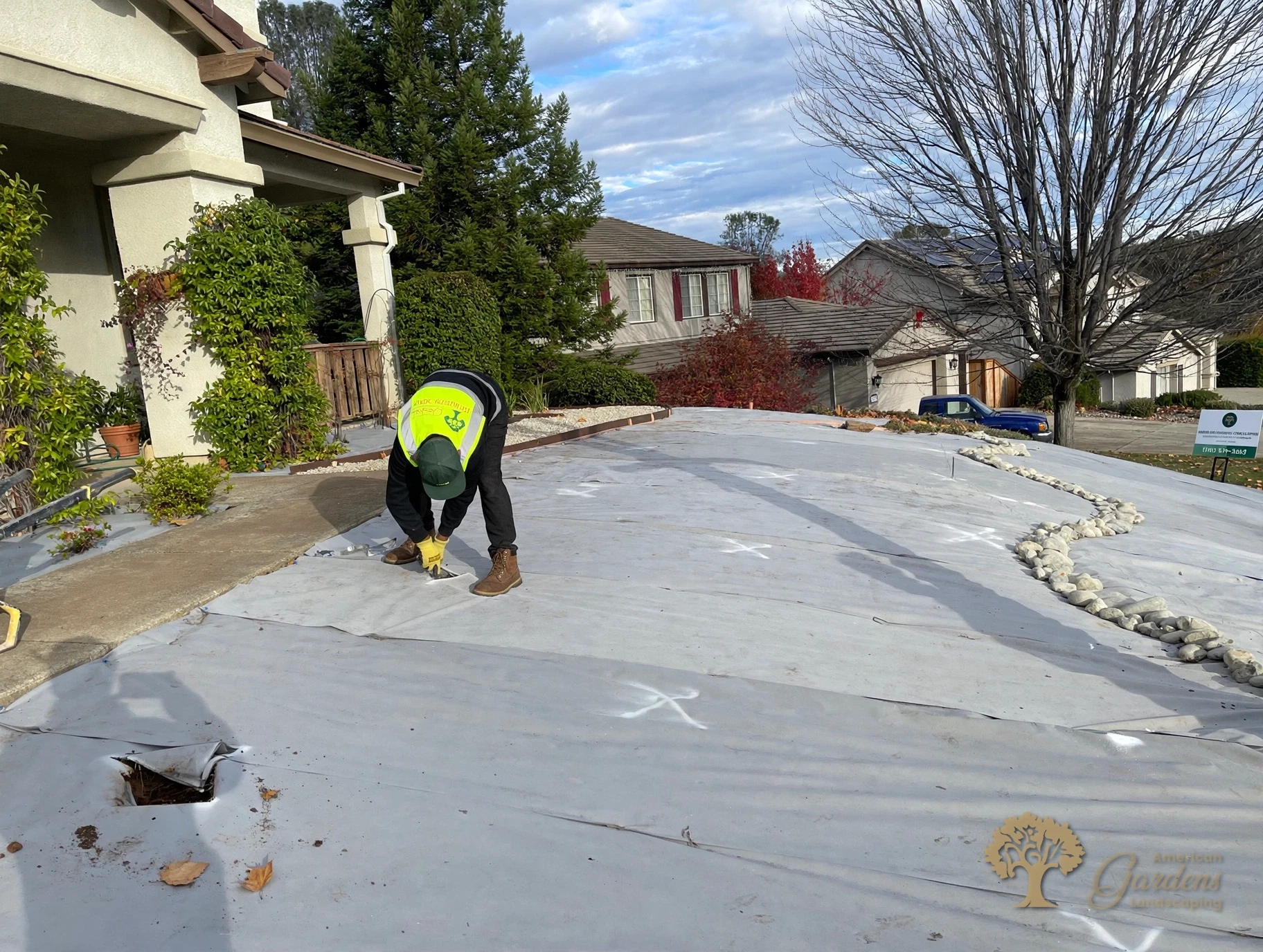 Cutting planting holes into the weed fabric in El Dorado Hills – American Gardens Landscaping