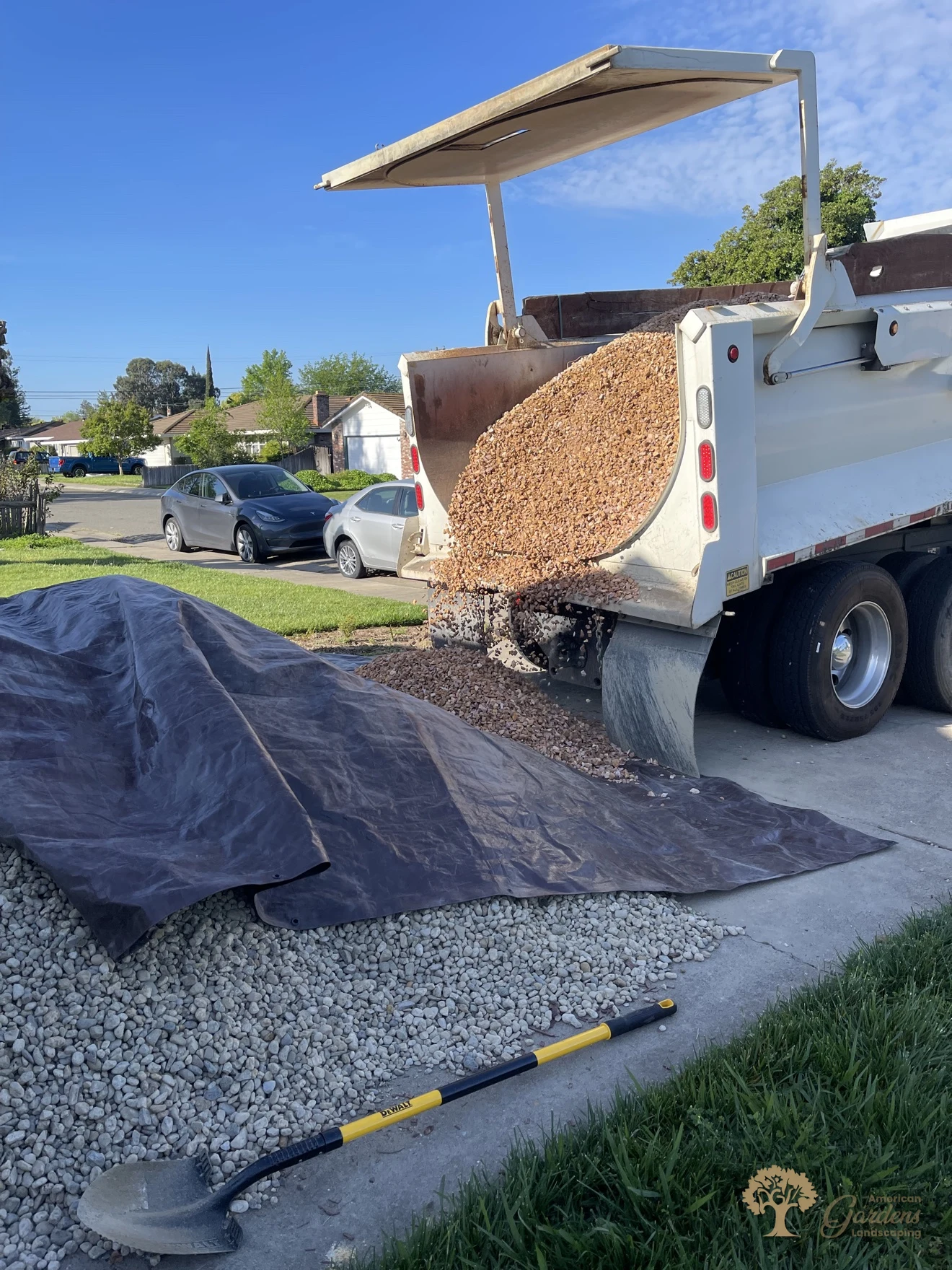 Dump truck delivering decorative rock for a xeriscape conversion in Carmichael